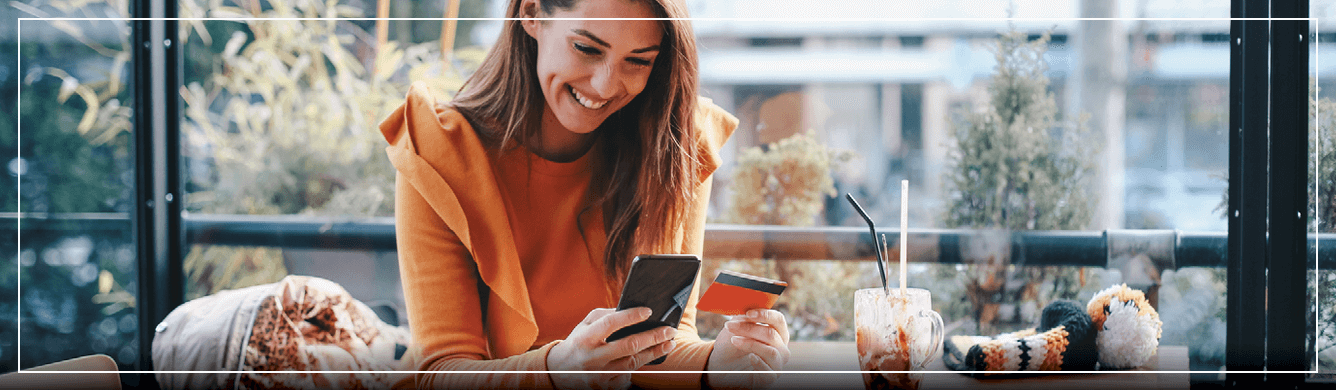 Woman Smiling holding credit card and phone