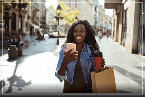 African American Woman shopping and looking at smart phone
