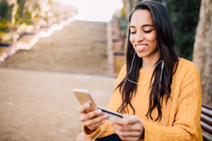 Young woman using mobile phone and credit card