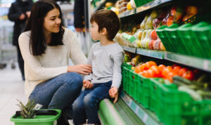 Mother and son at a grocery store with fruit