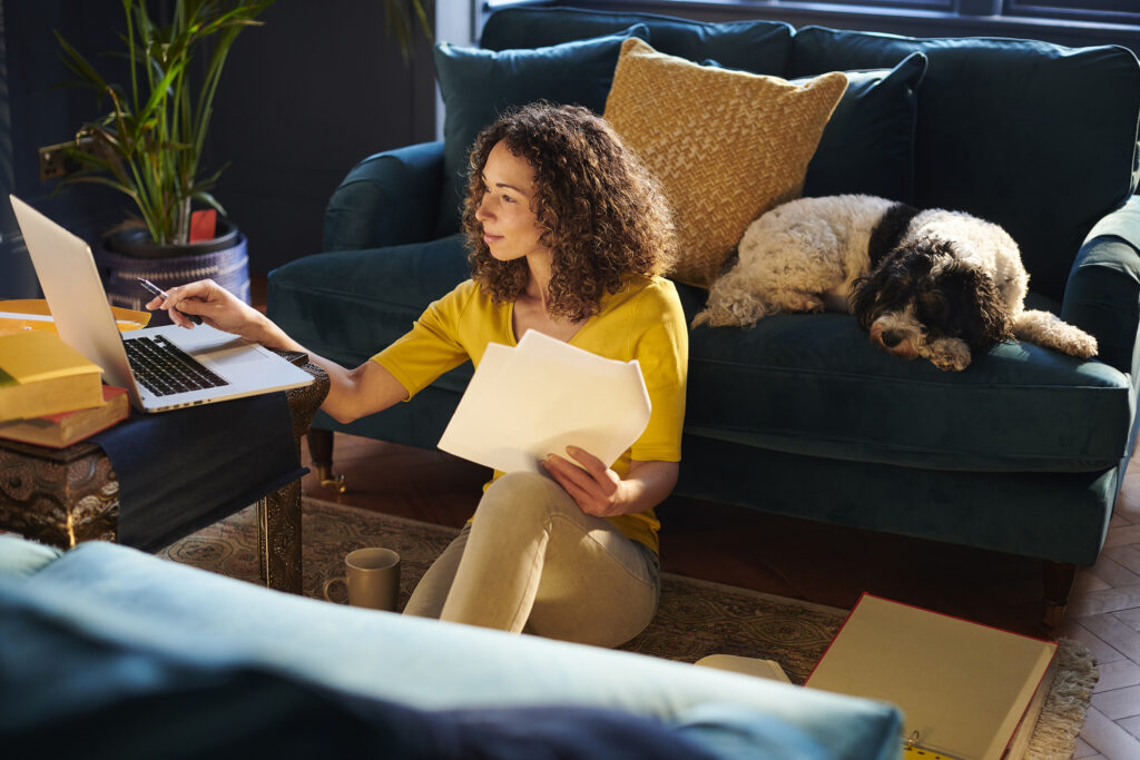 Young woman budgeting with laptop and dog