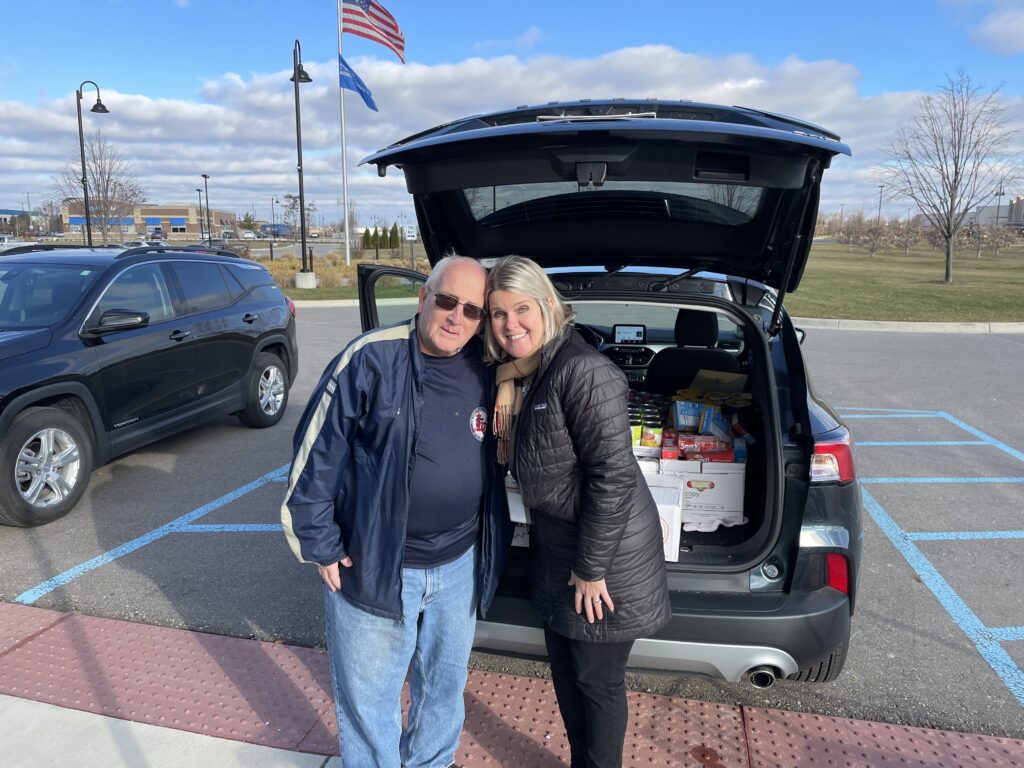 Canned food donation with two people smiling